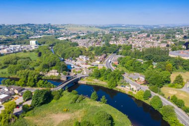 Kirklees, Batı Yorkshire 'daki Mirfield şehrinin hava aracı fotoğrafı güzel güneşli bir yaz gününde nehri geçen tren yolunu gösteriyor.