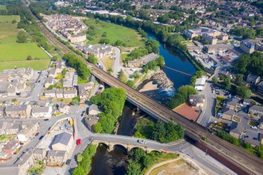 Kirklees, Batı Yorkshire 'daki Mirfield şehrinin hava aracı fotoğrafı güzel güneşli bir yaz gününde nehri geçen tren yolunu gösteriyor.