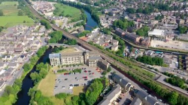 Kirklees, Batı Yorkshire 'daki Mirfield şehrinin hava aracı görüntüleri güzel güneşli bir yaz gününde nehri geçen tren raylarını gösteriyor.