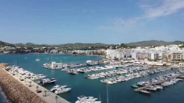 Ibiza, İspanya 'nın Balear adalarındaki güzel adasının Santa Eularia des Riu' da güneşli bir yaz gününde Akdeniz kıyısındaki sahil ve liman alanını gösteren hava görüntüleri.