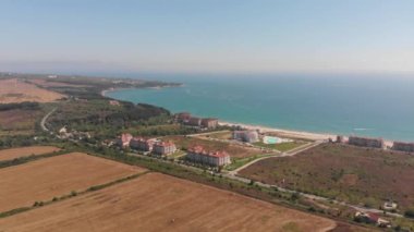 Bulgaristan 'ın güzel küçük kasabası ve sahil beldesi Obzor' un hava görüntüleri, arka planda okyanus ve plajlı tarlaları ve otelleri gösteriyor.