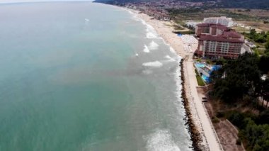 Bulgaristan 'ın Obzor kenti olarak bilinen güzel şehrin hava görüntüleri, sahildeki güneşli plajlarda insanların güneşlenip güneşlendiği ve güneşlendiği sahili gösteriyor.