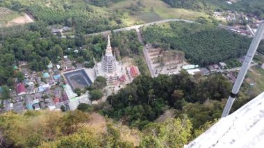 Landscape footage taken from the top the mountain known as The Tiger Cave Temple, a Buddhist temple north-northeast of Krabi in Thailand, showing the town of Krabi below along side the forest.