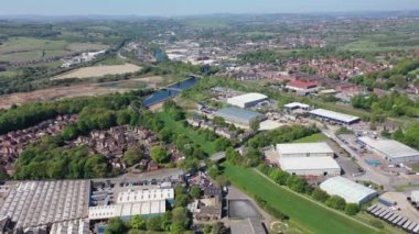 Aerial footage of the town centre of Dewsbury in West Yorkshire in the UK showing rows of terrace houses along side the train track going over the river calder