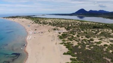 Aerial footage of the beautiful small town known as St George South in the city of Corfu Greece, showing the Labranda Sandy Beach Resort on the Issos Beach with mountains in the background
