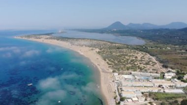 Aerial footage of the beautiful small town known as St George South, Greek city of Corfu Greece, showing the golden sandy Issos Beach on a cloudy day