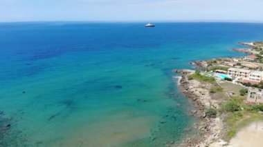 Panning beautiful aerial footage of the beach and coastal village of St George South in Corfu Greece showing the Agios Georgios Beach and holiday hotels and apartments