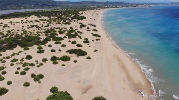 コルフのセント ジョージ サウスと呼ばれるビーチや海岸の休暇エリアを横断する美しい空撮映像ギリシャでは 砂丘の波がクラッシュし すべての茂みを示しています — ストック動画