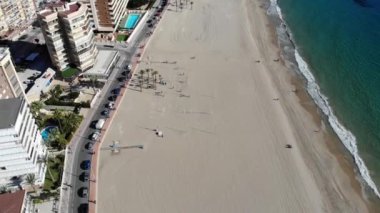 Aerial footage of Benidorm beach known as Playa Levante beach, hotels, buildings, restaurants and the coastline and sandy beaches of Benidorm the seaside resort in Spain Alicante.