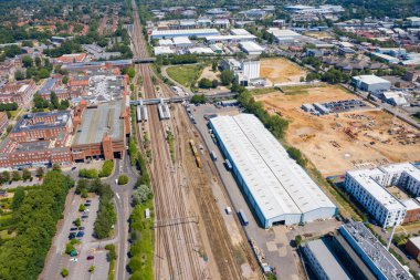 Aerial photo of the British town of Stevenage in Hertfordshire UK showing a a housing estate being built on a construction site along side the train station on a hot sunny summers day