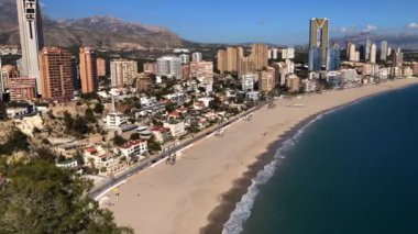 Time Lapse footage overlooking the Beautiful Playa Levante beach in Benidorm a seaside resort in Spain Alicante, showing hotels, buildings, the tide going in and out and people on the beach.