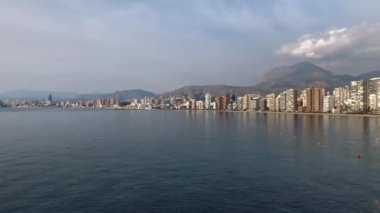 Time Lapse footage overlooking the Beautiful Playa Levante beach in Benidorm a seaside resort in Spain Alicante, showing hotels, buildings, the tide going in and out and people on the beach.