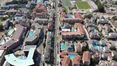 Aerial footage of the beautiful town centre of Sunny Beach in Bulgaria showing  hotels and hotel swimming pools from above, taken with a drone in the summer on a sunny day