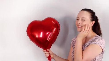 Yerde yatan çekici bir kadın mutlu, seksi ve her tarafına kırmızı gül yaprakları düşmüş.