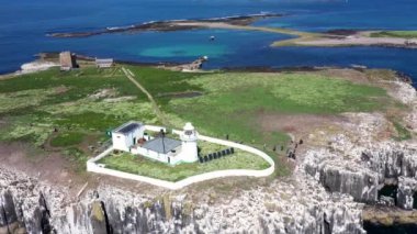 Inner Farne 'ın güney ucunda bir deniz feneri olan The Farne Lighthouse' ı gösteren İngiltere 'deki Deniz Evleri köyünün sahil kasabasının hava görüntüleri. 19. yüzyılın başlarında inşa edilmiş..