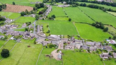 Aerial footage of the beautiful village of Thoralby in the Richmondshire district of North Yorkshire in the UK, showing the small British village and surrounding green fields in the summer time