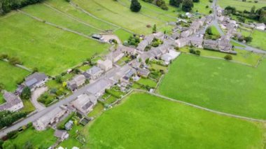 Aerial footage of the beautiful village of Thoralby in the Richmondshire district of North Yorkshire in the UK, showing the small British village and surrounding green fields in the summer time