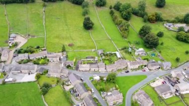 Aerial footage of the beautiful village of Thoralby in the Richmondshire district of North Yorkshire in the UK, showing the small British village and surrounding green fields in the summer time