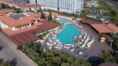 Türkiye 'nin güzel sahil beldesi Antalya' nın havuzda yüzen bir otel havuzu ve yaz mevsiminde havuzda eğlenen tatilcileri gösteren hava görüntüleri..
