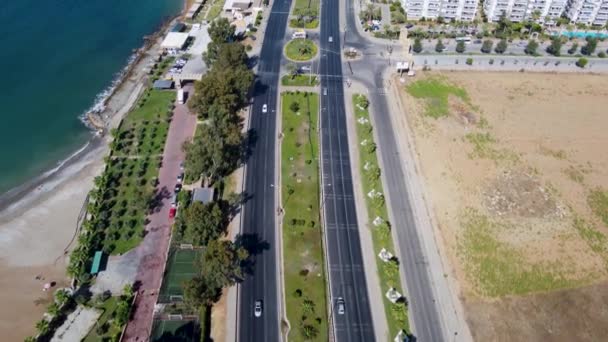 トルコのアンタルヤの美しいビーチリゾートの空中映像は ビーチやホテルで道路を走行する交通で海岸沿いの道路を示しています — ストック動画