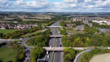 Güneşli bir yaz gününde, Sheffield UK 'in Barnsley köyünde çekilen, anayoldan geçen üç köprüsü olan işlek M1 otoyolunun hava aracı görüntüleri..