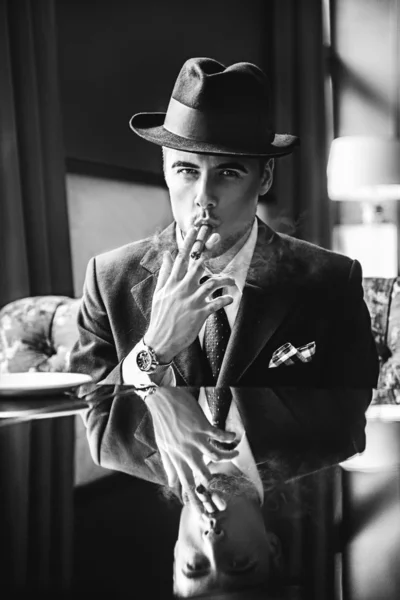 Podnikatel v klobouku kouří doutník v restauraci Royalty Free Stock Obrázky