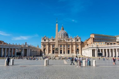 Vatikan St. Peter meydanındaki turistler. Aziz Peter Bazilikası 'nın panoramik manzarası ve onun aziz heykelleri. Vatikan Şehri, İtalya - 09.22.2021