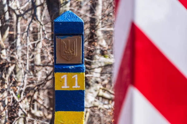 Border markes on a Polish-Ukraine boundary. The Polish eastern border, is also the border of the European Union and NATO. In the background, the blue sky and trees, bushes and grass of Bieszczady Mountains National Park, Poland