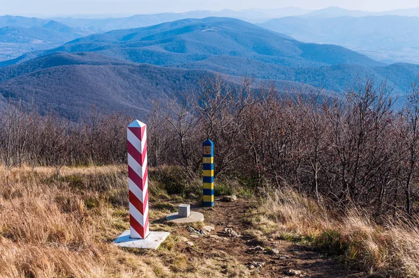 Border markes on a Polish-Ukraine boundary. The Polish eastern border, is also the border of the European Union and NATO. In the background, the blue sky and trees, bushes and grass of Bieszczady Mountains National Park, Poland