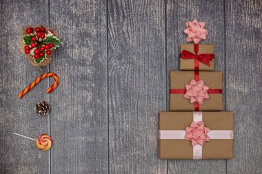 Kahverengi ahşap arka planda tatil hediyeleri ve lolipoplar. Yeni yıl ve Noel konsepti. Düz yatıyordu.