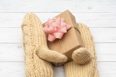 Bir bayram hediyesi örülmüş yün eldivenlerle kaplıdır. Kışın, Noel, Sevgililer Günü, Doğum Günü 'nde kutlanan tatiller için tebrikler..