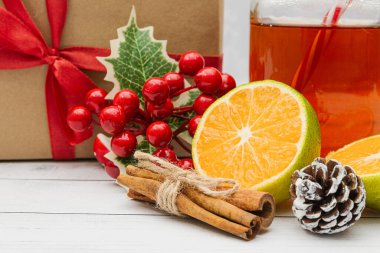 Cam kavanozda siyah çay, limon, tarçın ve beyaz ahşap arka planda hediye kutusu. Noel ve Yeni Yıl kavramı.