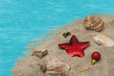 Tatlılar, hediyeler, deniz kenarındaki kumsalda deniz kabukları. Noel ve Yeni Yıl 'da denize seyahat kavramı.