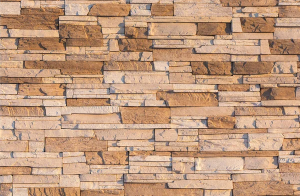 A parede é enfrentada com pedra marrom. Construção textura de pedra Imagem De Stock