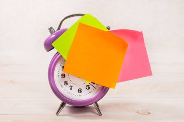 Mor çalar saatin turuncu boş bir çıkartması var. İş planlama ve geliştirme kavramı.