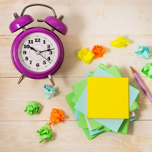 Masanın üzerinde bir çalar saat, bir not defteri ve boş sarı bir kağıt parçası var. Öğretmenlik ya da iş geliştirme konsepti. Düz yatıyordu.