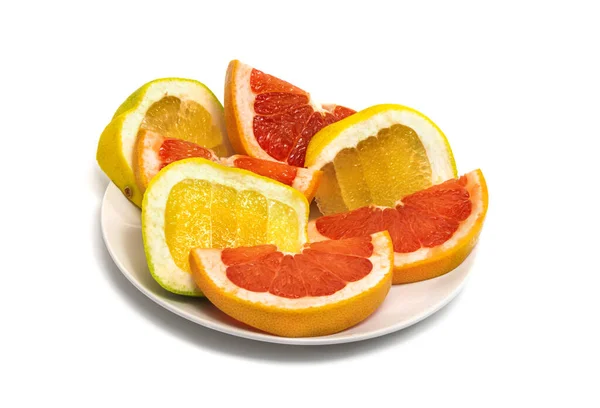 On a white plate are citrus slices: orange, grapefruit and pomelo. Isolated — Fotografia de Stock