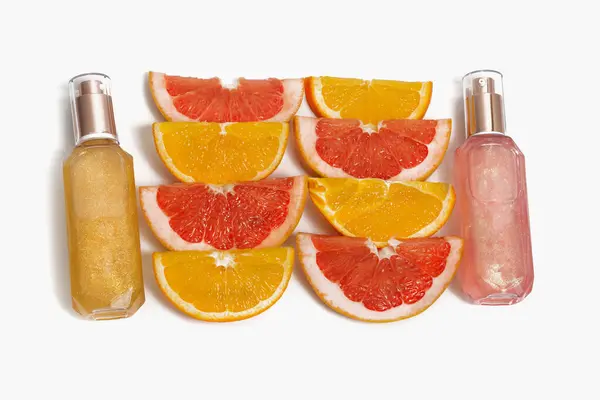 Slices of grapefruit, orange and two bottles of colorful shower gel. Natural cosmetics concept — Fotografia de Stock