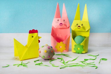 Origami tekniğinde yapılan kağıt hayvanların sevimli kompozisyonu. Paskalya tavşanı yumurta tutacağı..