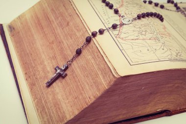 Eski, çok kalın bir İncil ve kutsal bir tespih. Katoliklik. Dua zamanı.