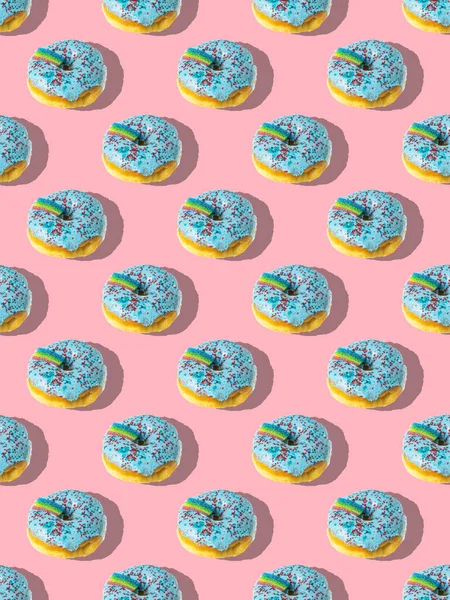 분홍빛 배경에 무지개가 파란색 도넛의 반복되는 — 스톡 사진
