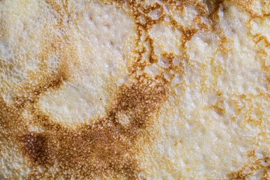 Pancake surface texture and pattern. Close-up of thin hot pancakes in a plate. Traditional rustic food. Graphic resource. Table top view.