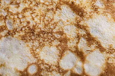 Pancake surface texture and pattern. Close-up of thin hot pancakes in a plate. Traditional rustic food. Graphic resource. Table top view.