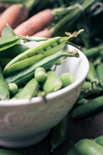 Vainas de guisante en un tazón con zanahorias —  Fotos de Stock