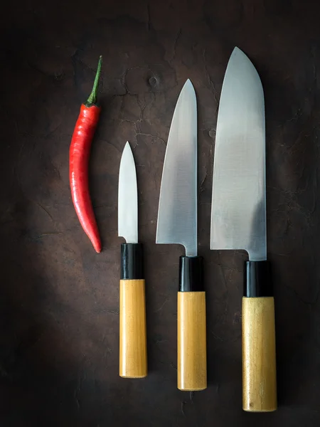 Japonský nůž na staré kožené s chilli — Stock fotografie