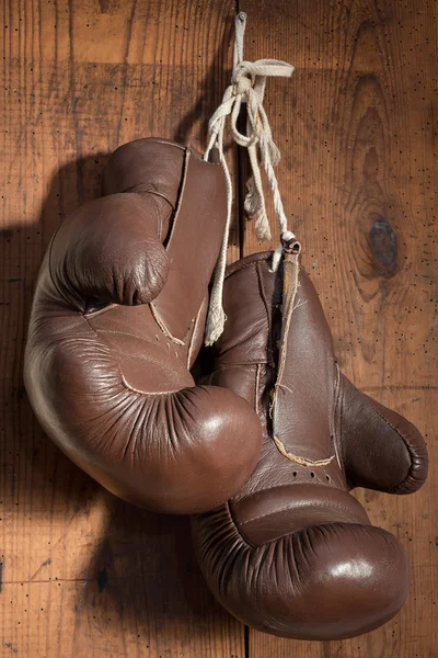 Старые боксерские перчатки, висящие на деревянной стене — стоковое фото