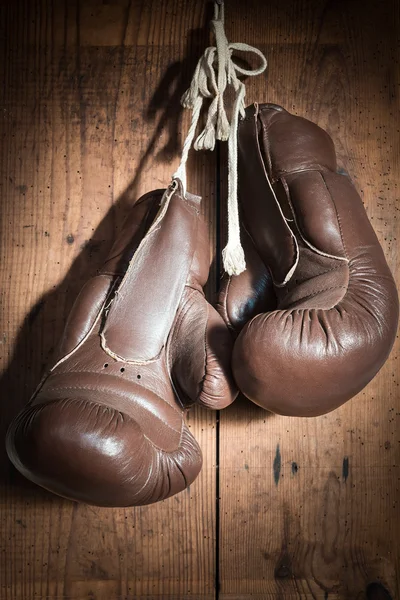 Viejos guantes de boxeo, colgando en la pared de madera — Foto de Stock