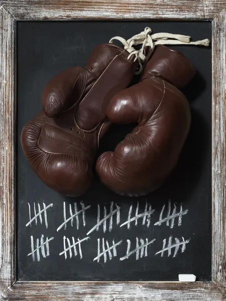 Старые боксерские перчатки на доске с табличкой — стоковое фото