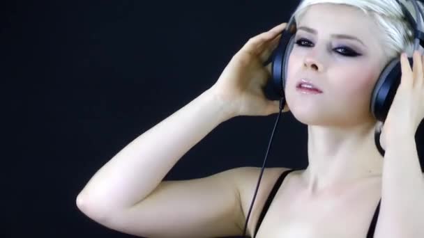 Ξανθιά γυναίκα ακούγοντας μουσική με ακουστικά — Αρχείο Βίντεο