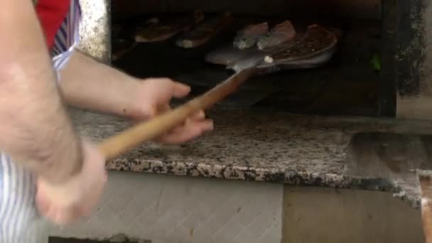 Добавление турецкой мясной питы в горячую духовку — стоковое видео